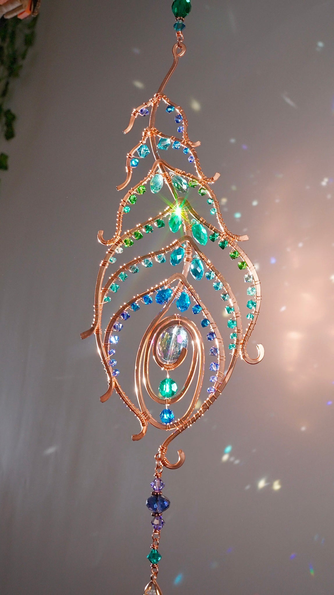 Peacock feather gemstone suncatcher fills the room with sparkles from crystal prism beads