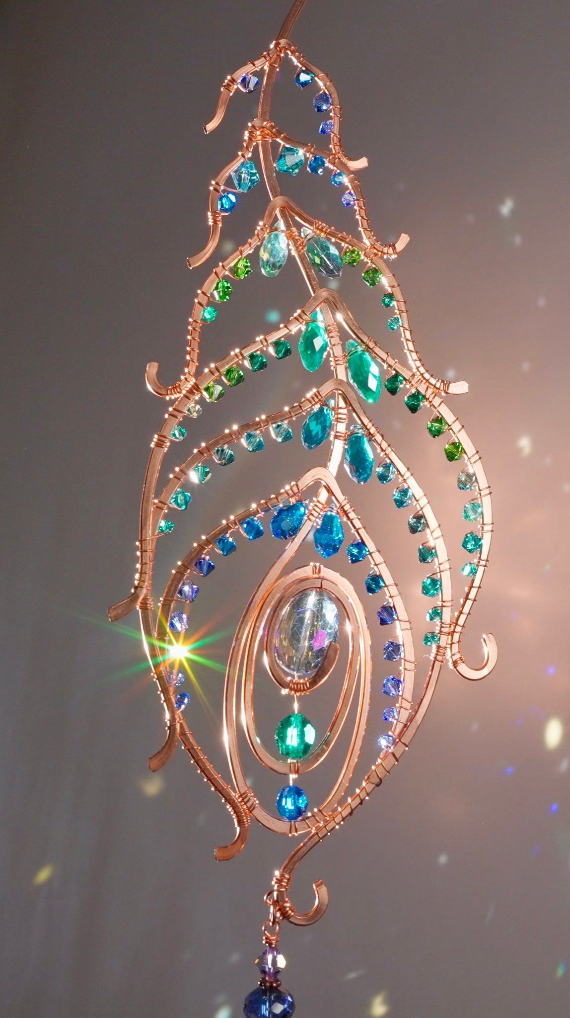 Peacock feather gemstone suncatcher fills the room with sparkles from crystal prism beads