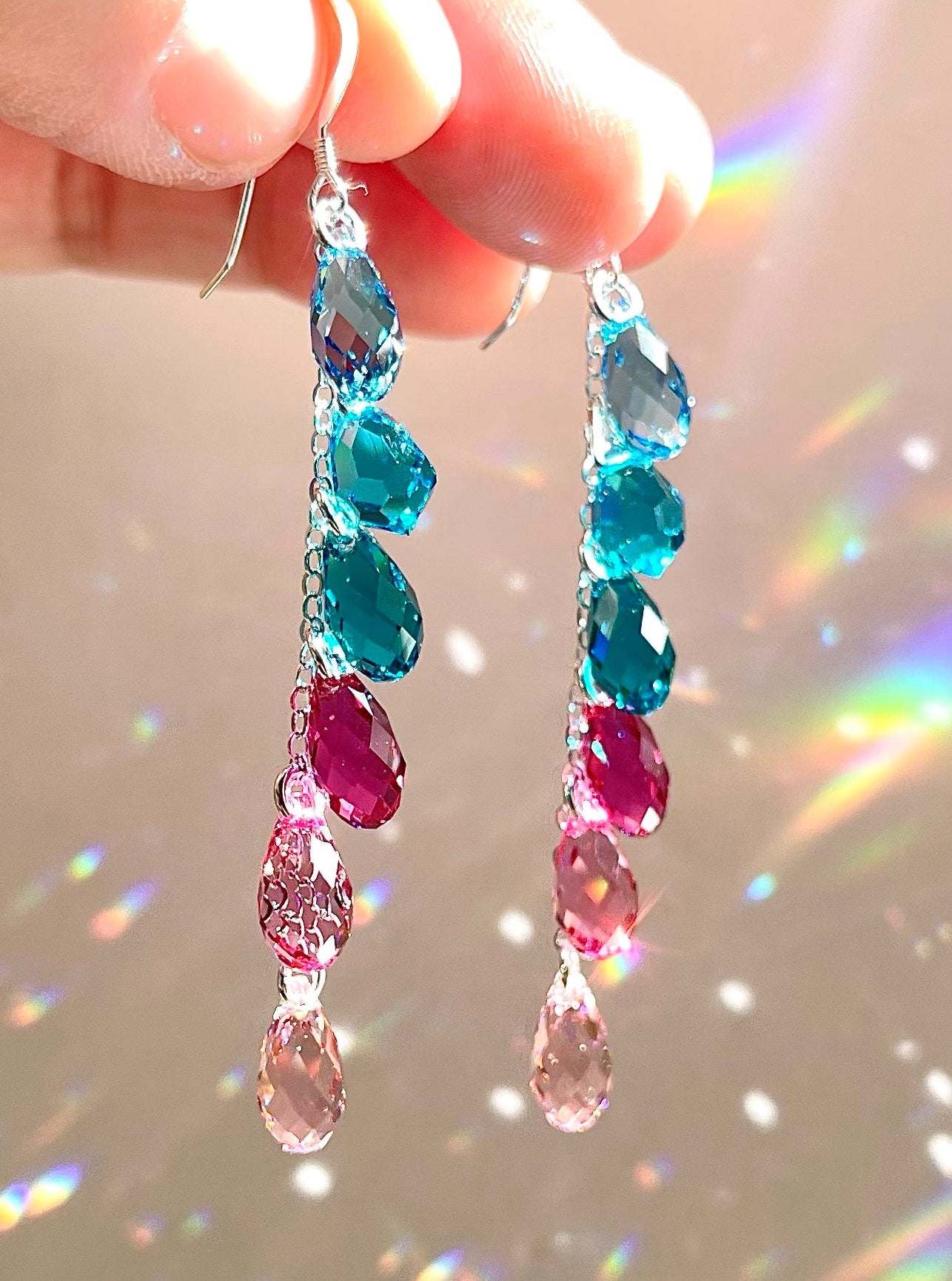 Magenta Pink and Aqua Teal Crystal teardrop cascade earrings arranged in an ombré color gradient