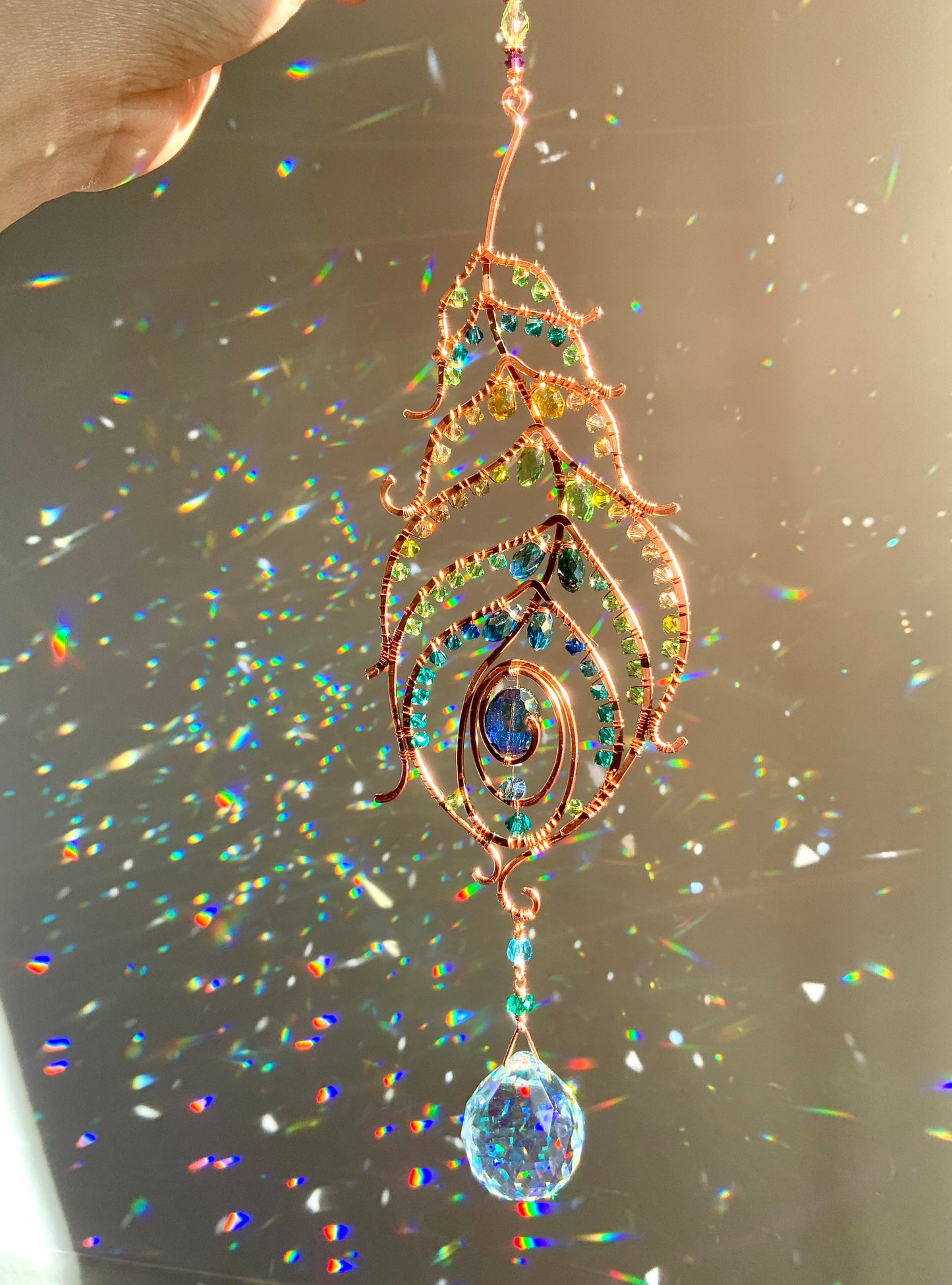 Peacock feather gemstone suncatcher fills the room with sparkles from crystal prism beads